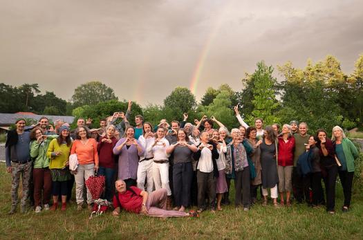 Edito - ZEGG Gemeinschaft vor dem Campus mit Regenbogen